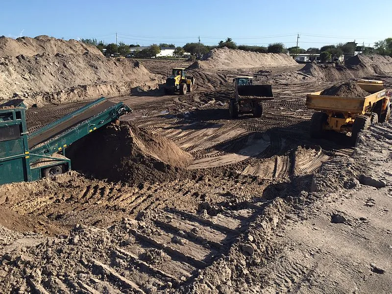 Earthmoving equipment and dump truck working a large earthwork site
